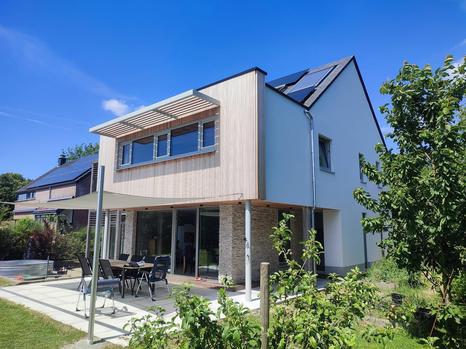 Maison contemporaine avec extension bois et soubassement en pierre, réalisation François Kerremans