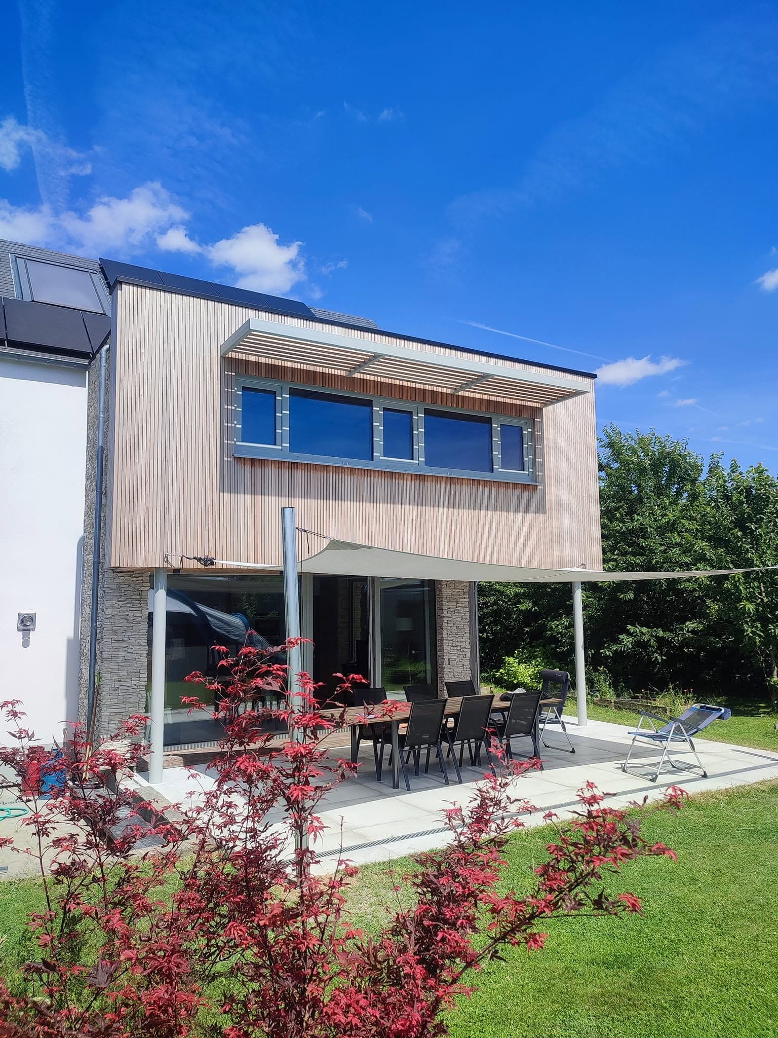 Maison contemporaine avec bardage bois et terrasse, réalisation François Kerremans en Brabant wallon